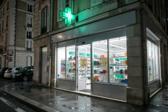 Pharmacie de garde ouverte la nuit avec croix verte lumineuse et panneau d'information dans l'Oise